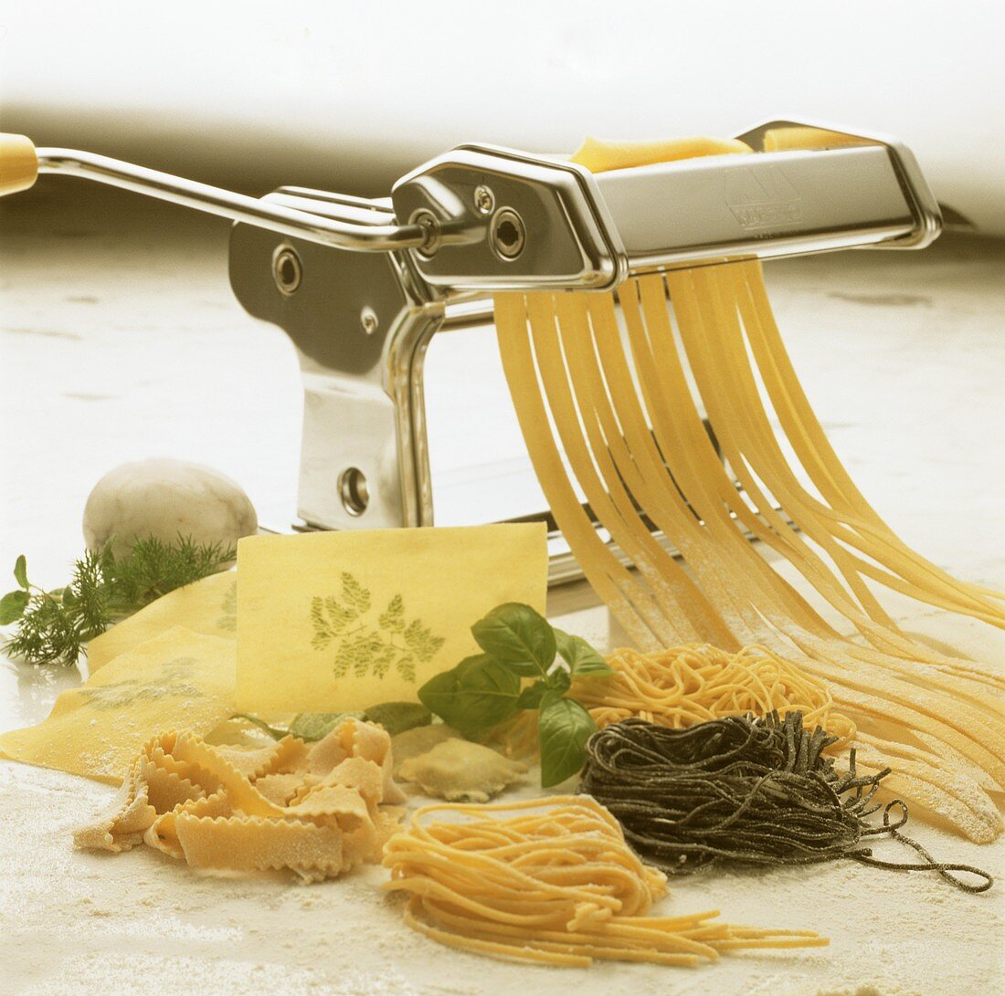 Still life: pasta dough in pasta machine, various pastas