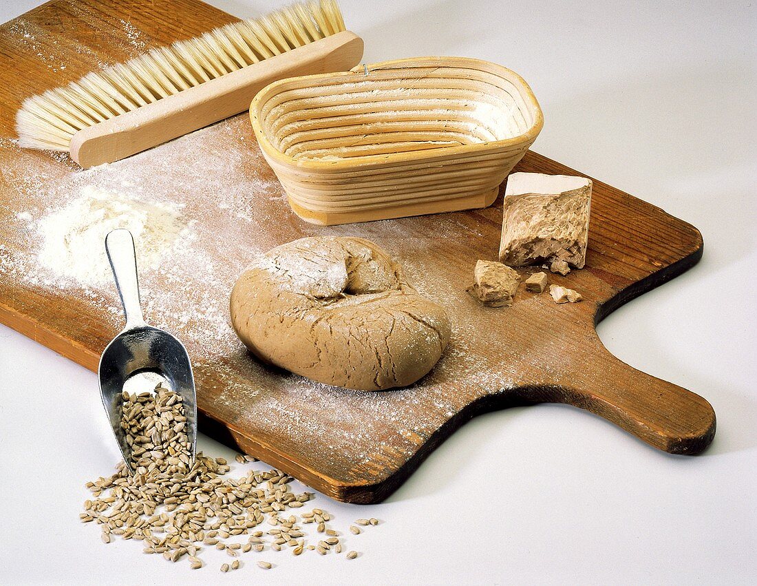 Brot backen: Stillleben mit Teig, Zutaten & Brotform auf Brett