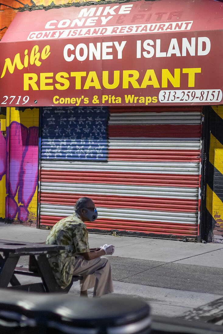 Man outside shuttered restaurant during Covid-19 outbreak