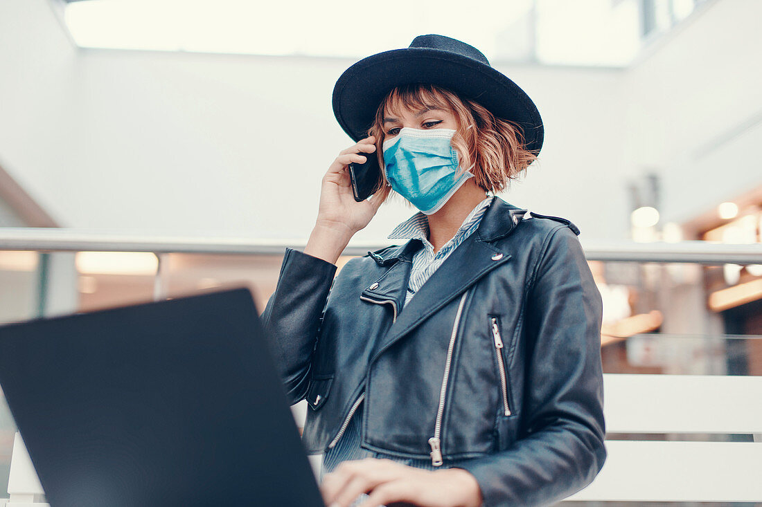 Busy woman in face mask making phone call