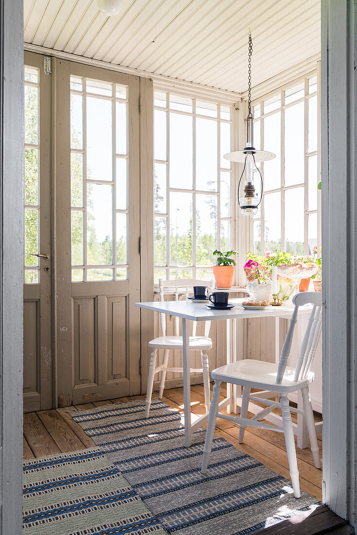 Set table below vintage oil lamp in conservatory