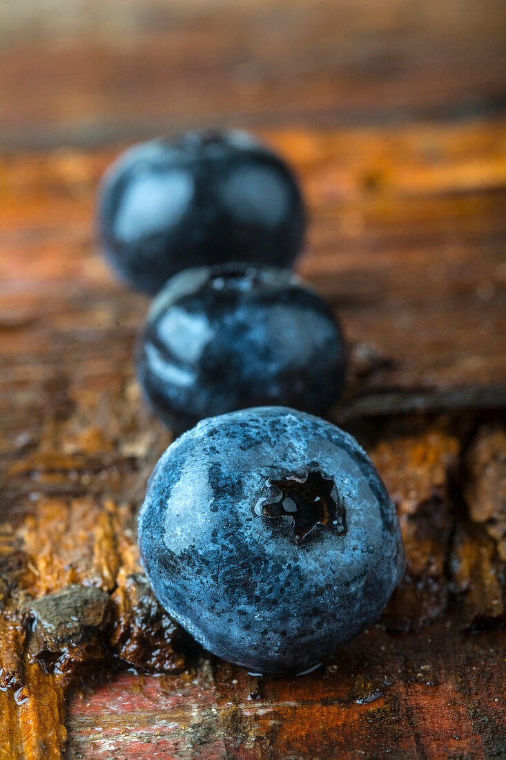 Frische Blaubeeren auf Holzuntergrund (Nahaufnahme)