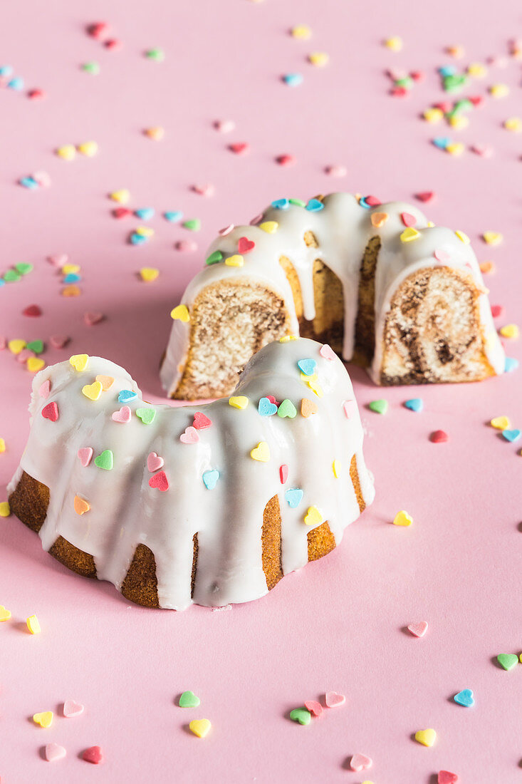 Bundt cake with white glaze and colorful heart shaped sugar sprinkles for Valentine's Day