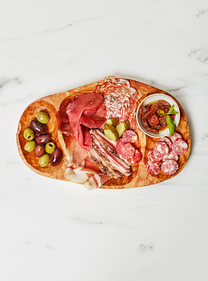 Feinkostplatte mit Wurst, Salami, Schinken, Oliven und getrockneten Tomaten
