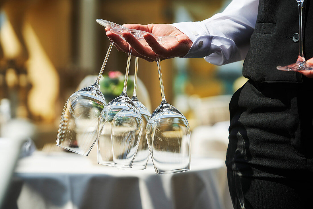 A waiter holding wine glasses