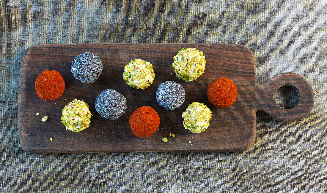 Date and goat's cheese balls with pistachio nuts, poppyseeds and ground paprika