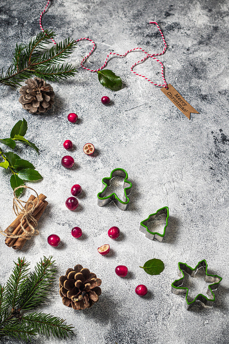 Weihnachtsstilleben mit Cranberries, Ausstechformen, Zweigen und Zapfen