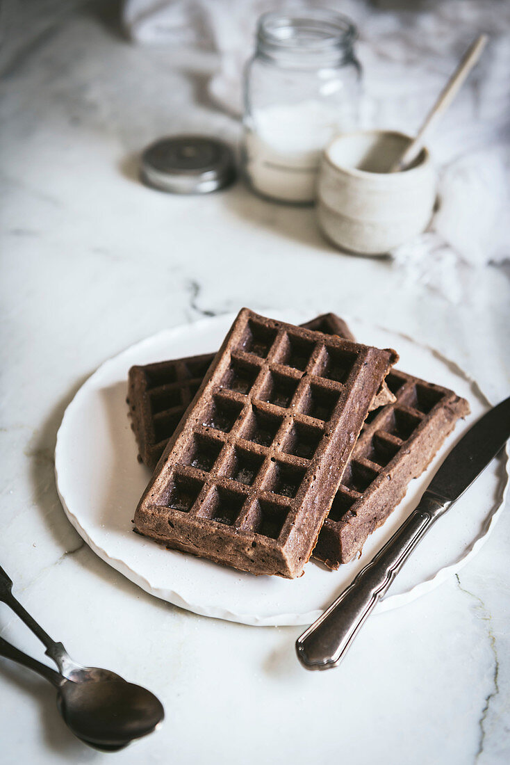 Oatmeal chocolate waffles with gooseberries served on white plate