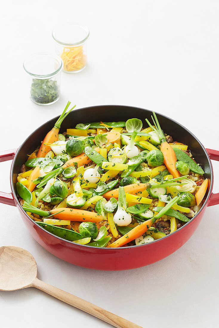 Summer vegetarian paella with carrots, Brussels sprouts and mange tout