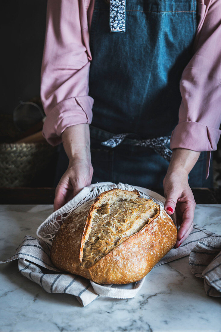 Hände halten frisch gebackenes Brot