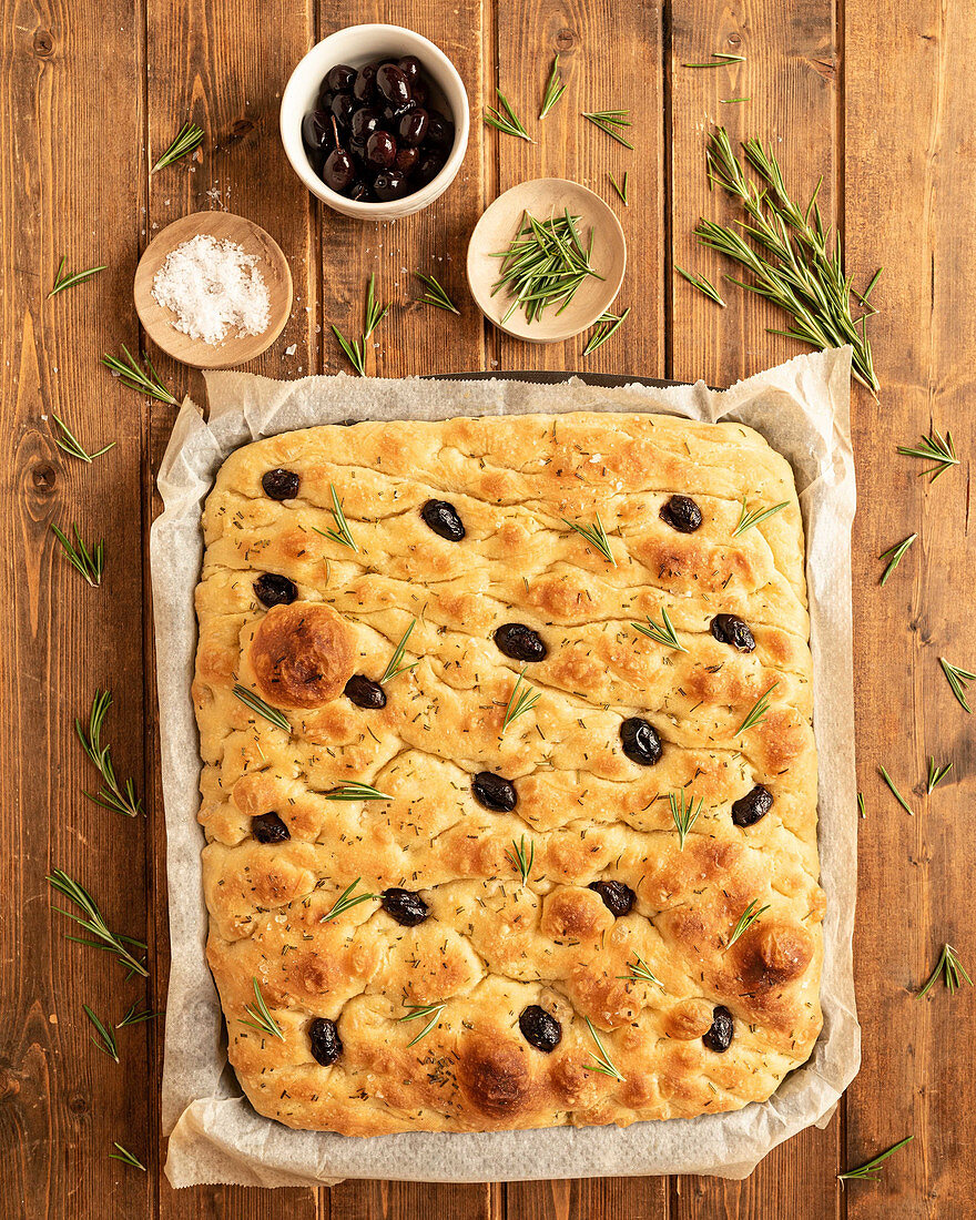 Traditional Italian whole focaccia bread with olives and rosemary