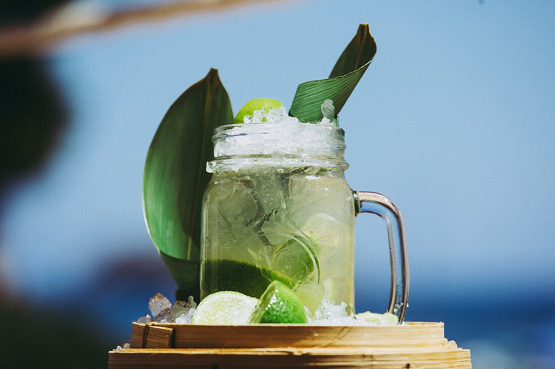 Cocktail mit Limetten und grünen Blättern
