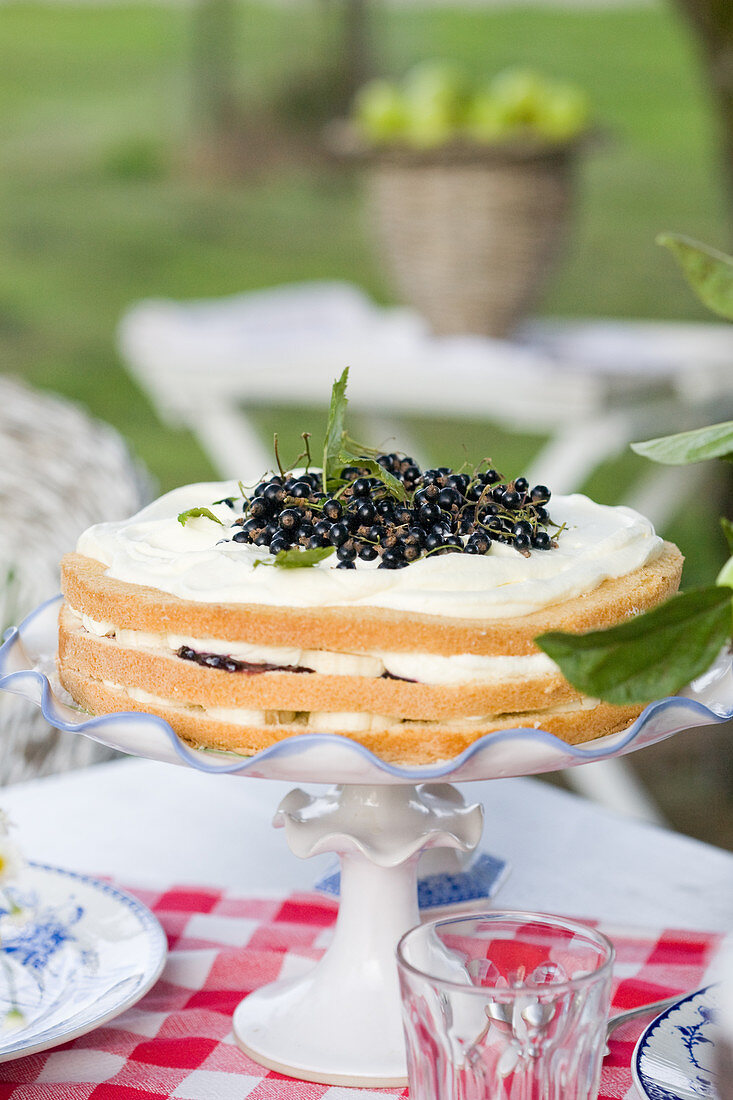 Schichttorte mit Brombeermarmelade, Johannisbeeren, Bananen und Vannillesahne