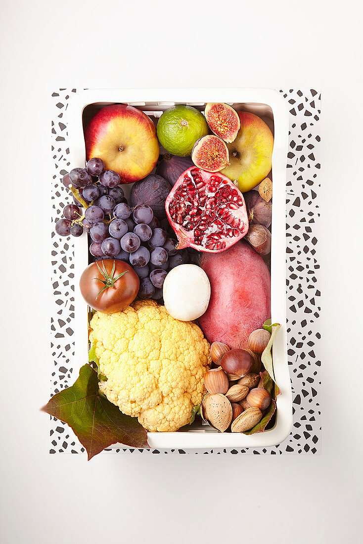 An arrangement of fruit, vegetables, nuts and egg
