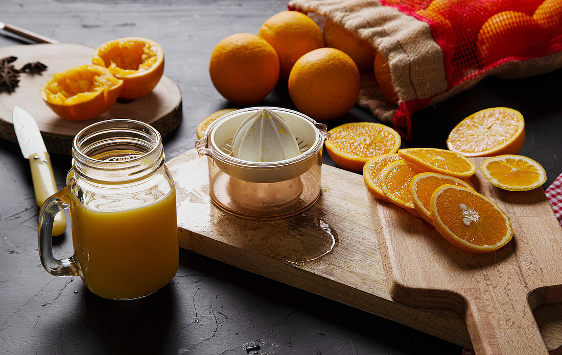 Frisch gepresster Orangensaft, Zitruspresse und Orangenscheiben