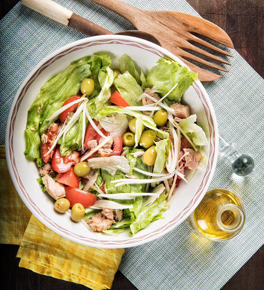 Healthy delicious salad with fresh tomatoes and lettuce with green olives and chicken served in bowl
