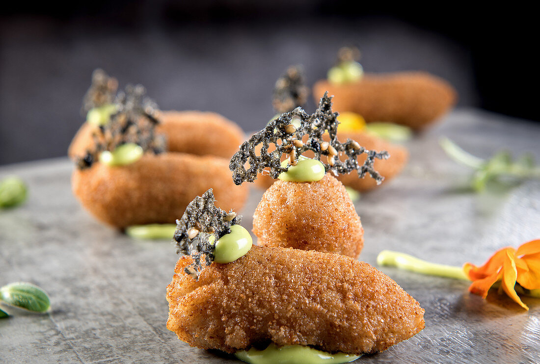 Gebratene Kartoffel-Hähnchen-Kroketten, garniert mit Kräutern