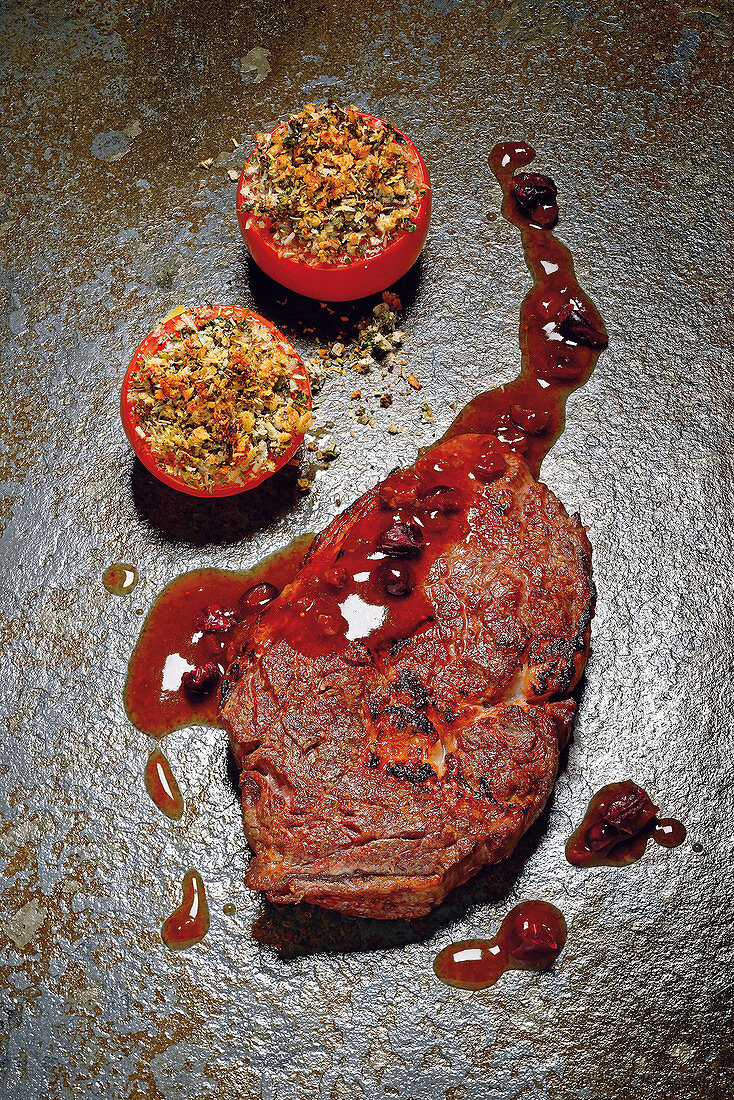 Grilled entrecôte with cranberry jus and gratinated herb tomatoes