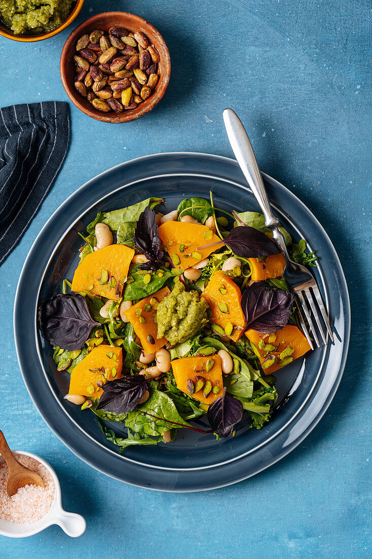 Vegan salad and fork placed on blue table