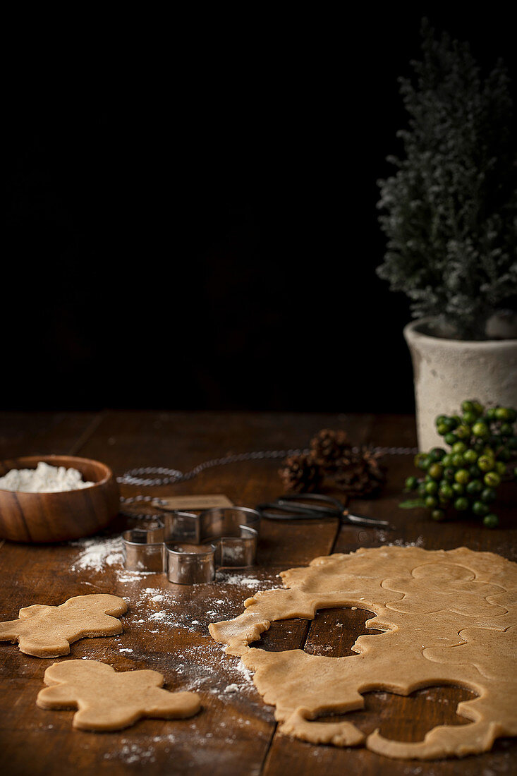 Lebkuchenteig und Ausstecher auf Holztisch