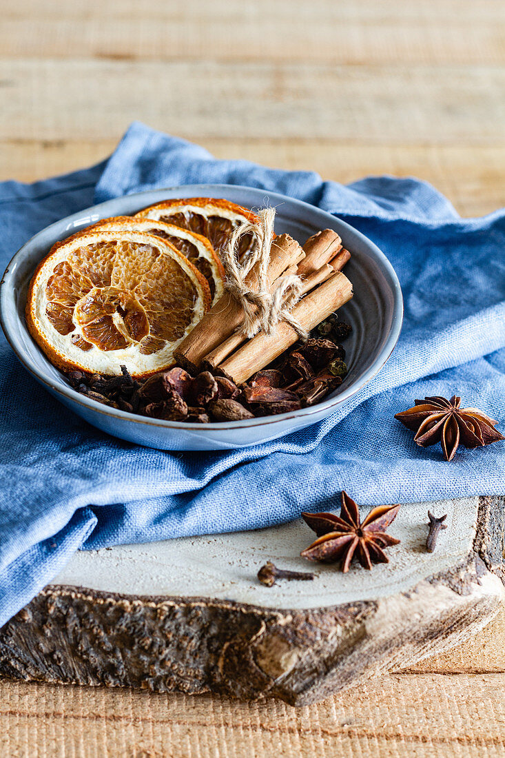 Cinnamon sticks and dried oranges arranged on table with star anise and cloves