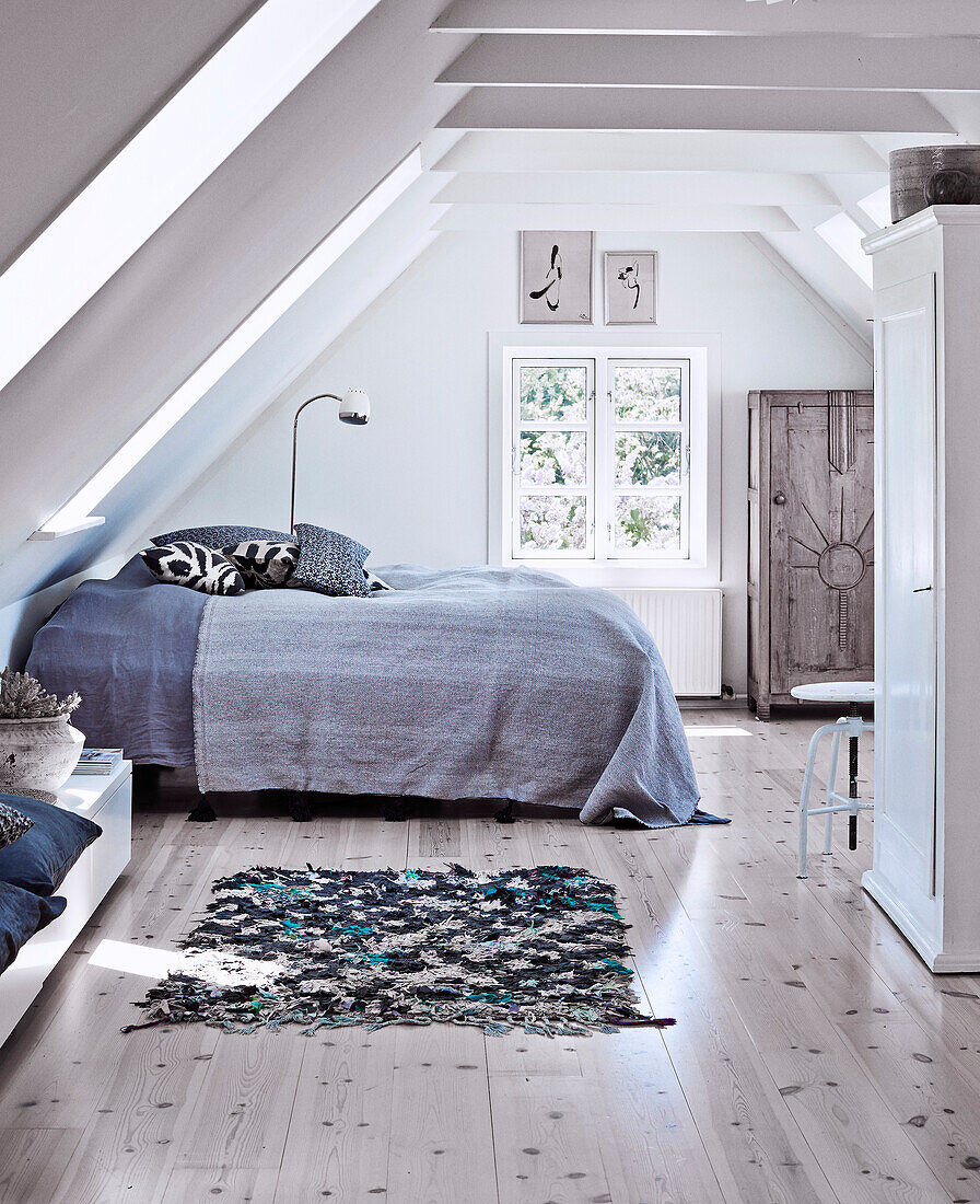 Doppelbett mit Tagesdecke und weißer Kleiderschrank im Schlafzimmer