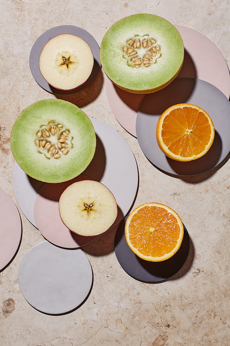 A Gallia melon, an apple and an orange – halved