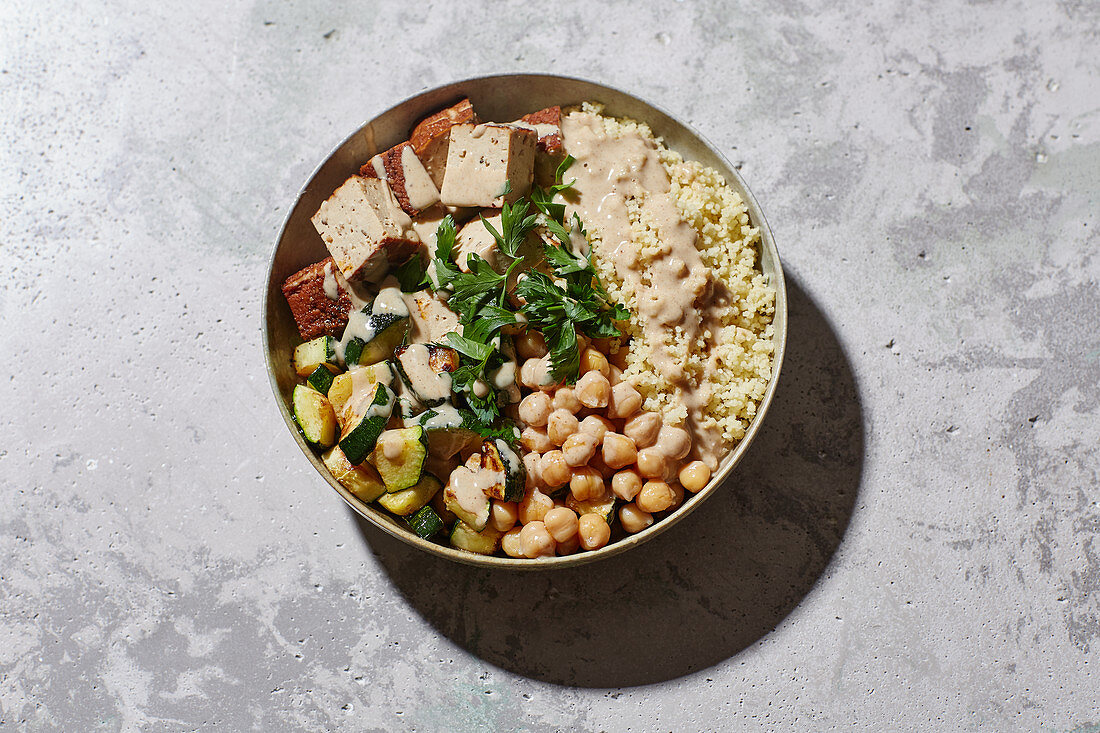 An oriental bowl with couscous, chickpeas, courgette and tofu