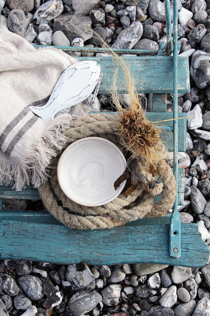 Maritime Deko auf verwittertem Stuhl am Strand