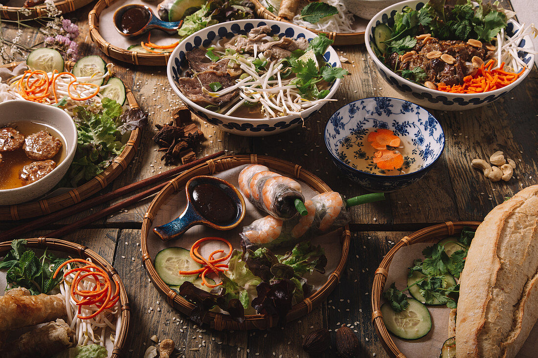 Assorted dishes of Vietnamese cuisine arranged on wooden table