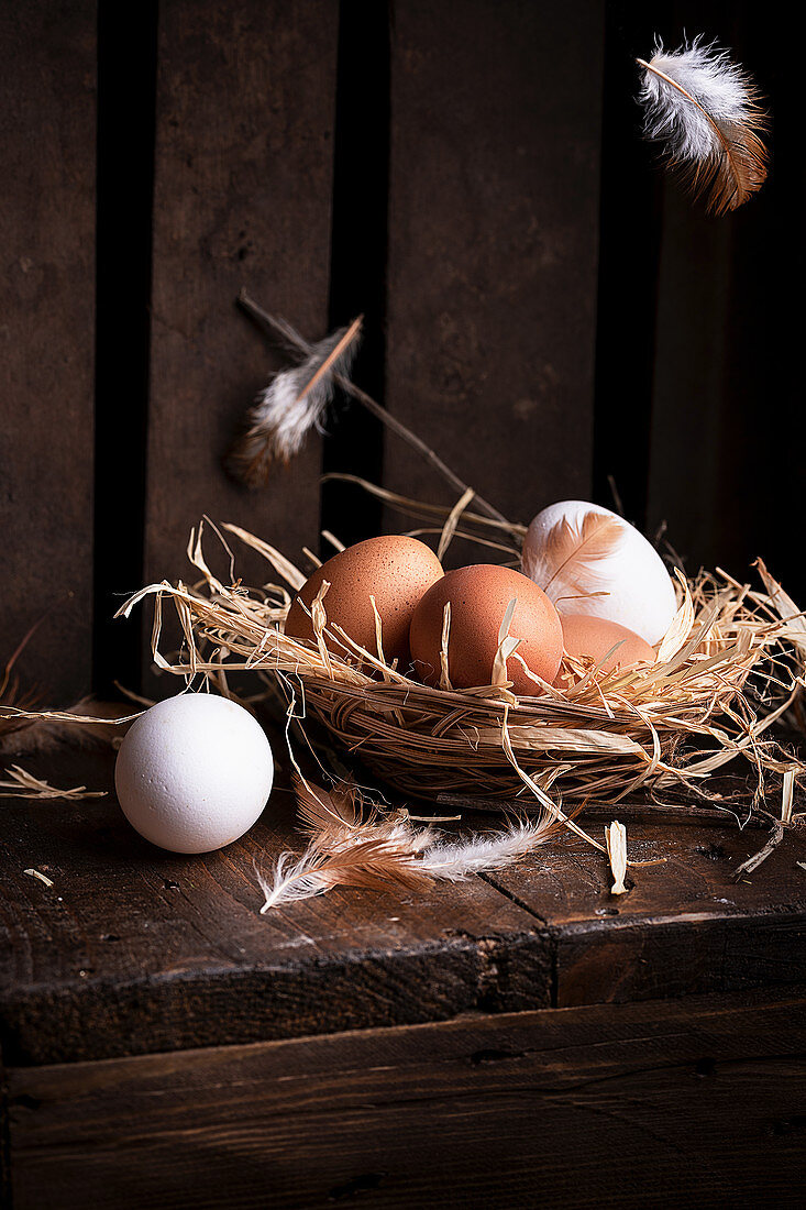 White and brown chicken eggs in straw nest