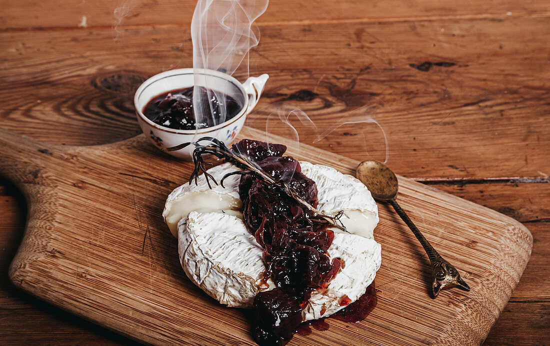 Camembert cheese with cherry jam garnished with rosemary