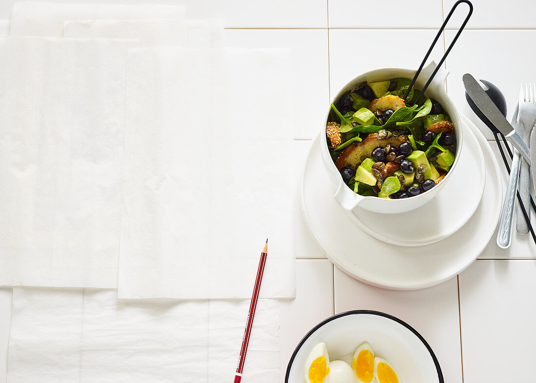 Spinach and grilled bread salad with boiled eggs and blueberries