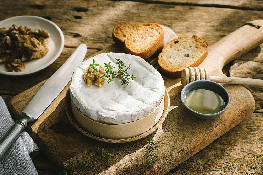 Baked camembert with walnuts on wooden table