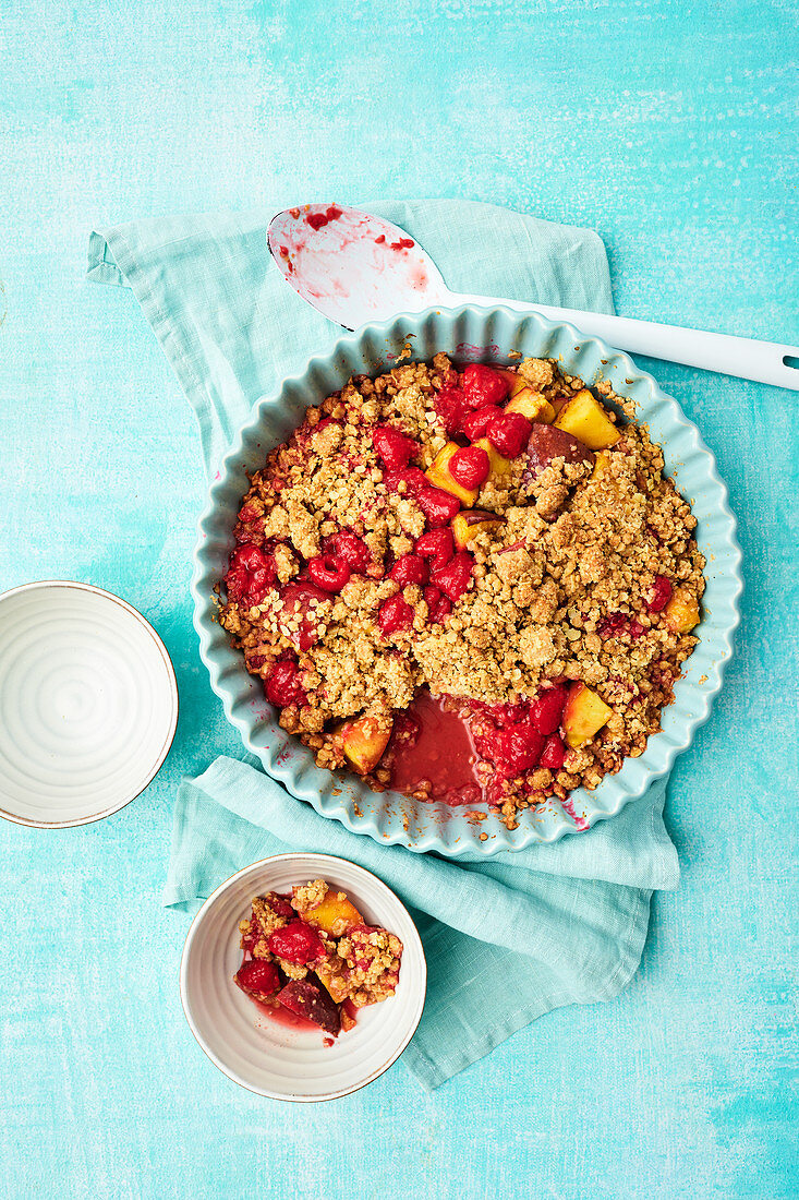 A raspberry and peach crumble topped with oat crumbles