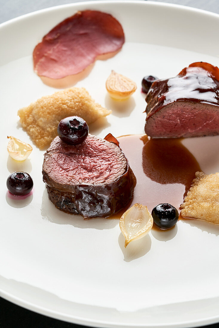 Saddle of venison with potato turnovers and blueberries