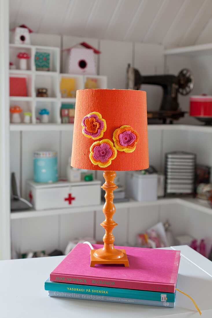Orange table lamp decorated with crocheted flowers