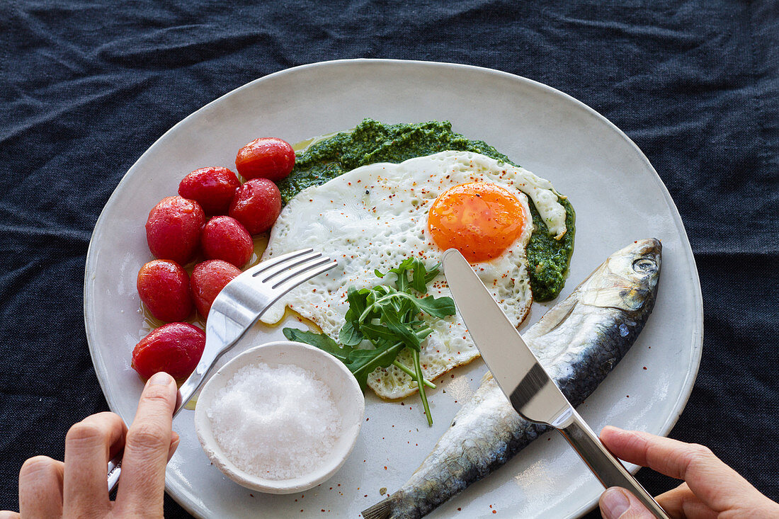 Fried egg, with salty herring, marinated tomatoes and pesto sauce