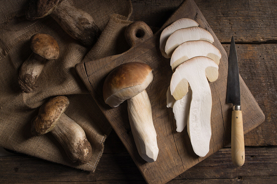 Raw whole and sliced porcini or on cutting board