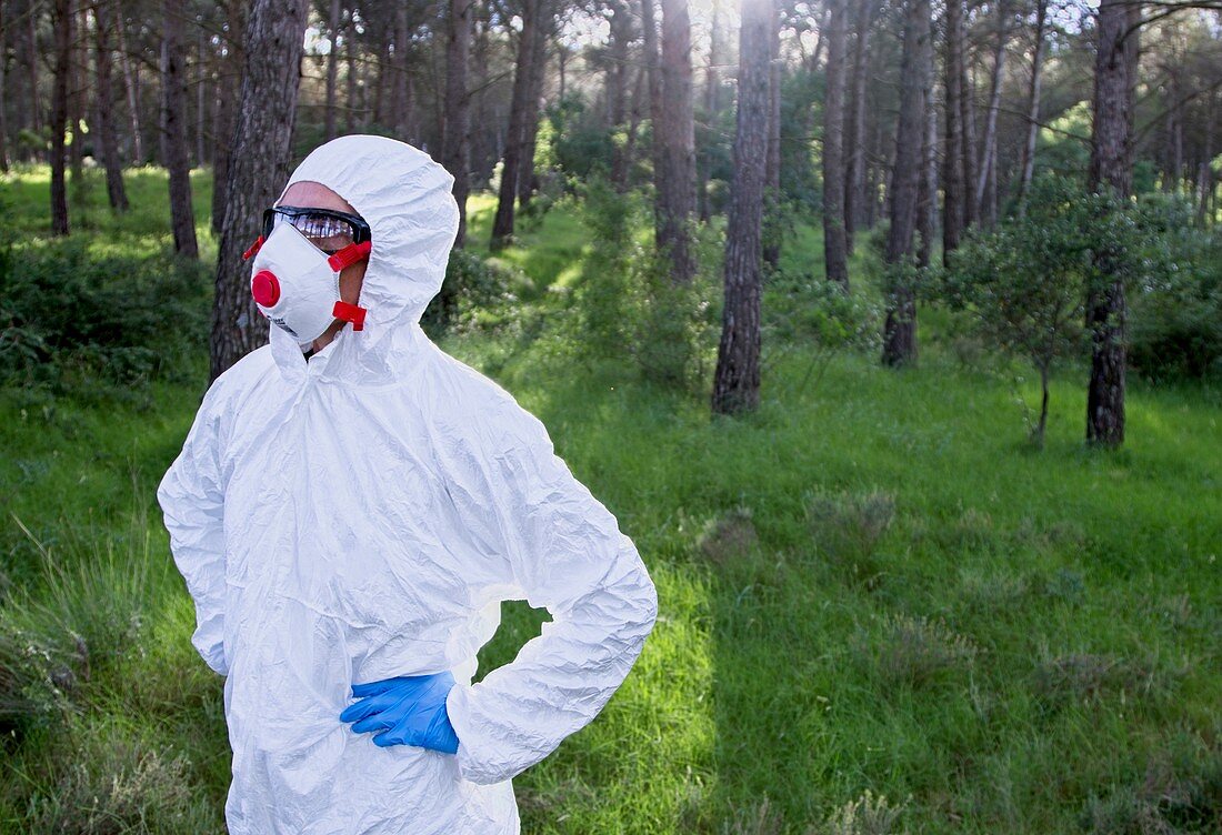 Person in protective suit in forest