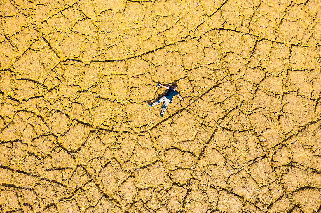 Man on cracked land, aerial view