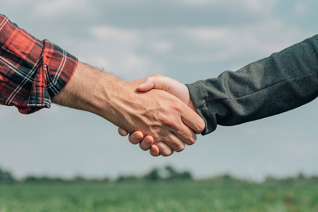 Mortgage loan officer and farmer shaking hands