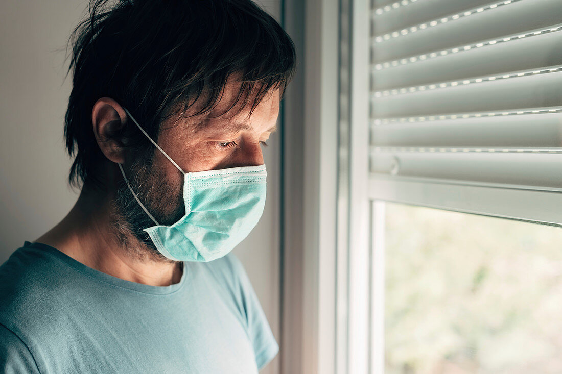 Depressed man with protective mask in quarantine