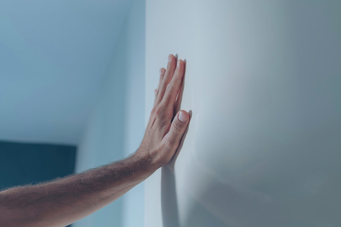 Male hand leaning on white interior door