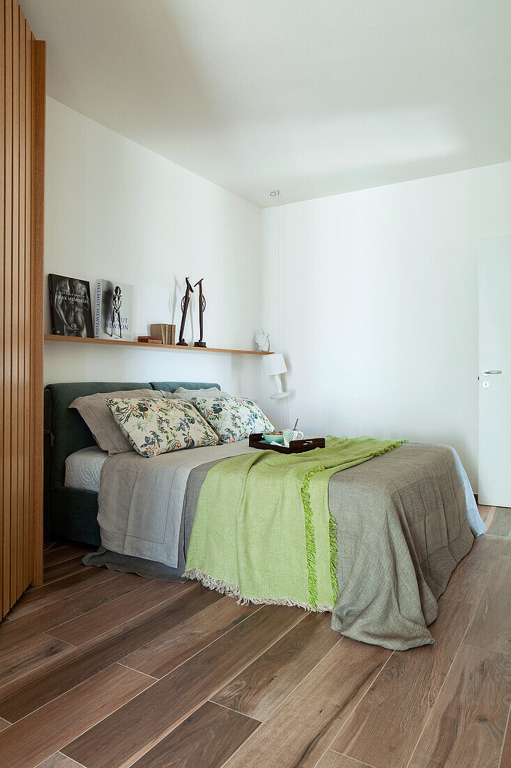 Doppelbett, darüber Regal im Schlafzimmer