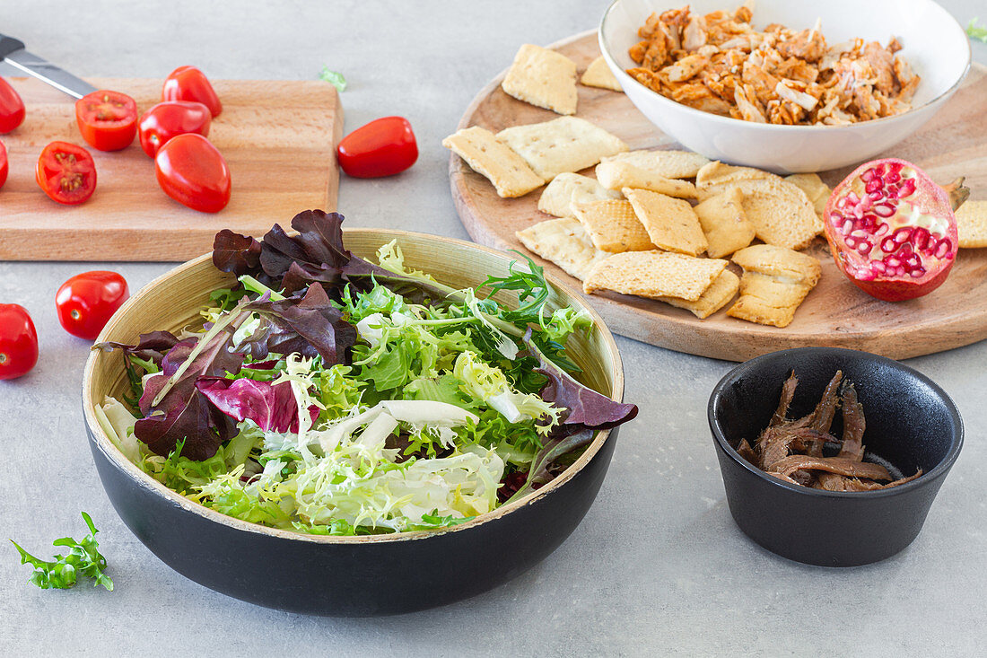 Bowl of green mix and ingredients for Caesar salad