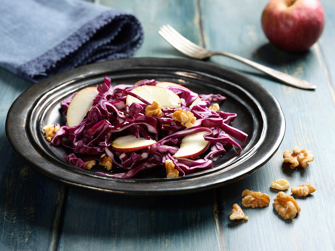 Red cabbage salad with apples wedges and piece of nuts