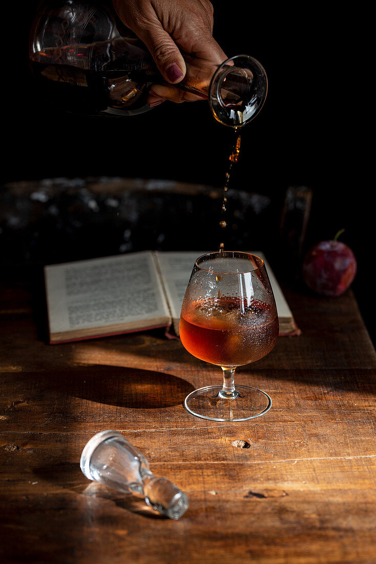 Cognac aus Karaffe in Glas gießen