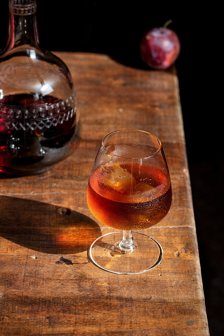 Glas Cognac mit Eiswürfeln und Karaffe