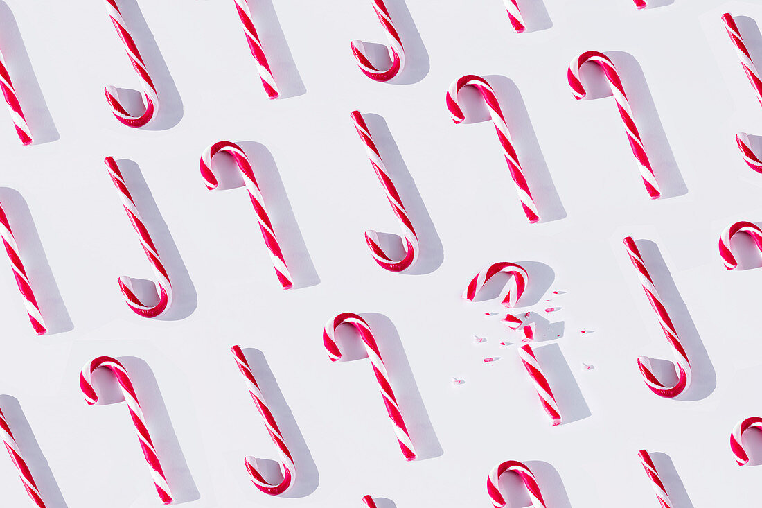 Red and white striped Xmas candy canes arranged in rows